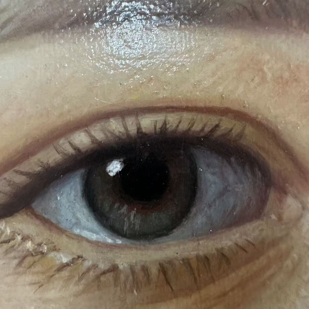 Macro photograph of a painted eye, showing the iris, the lashes and the raised highlight in the paint