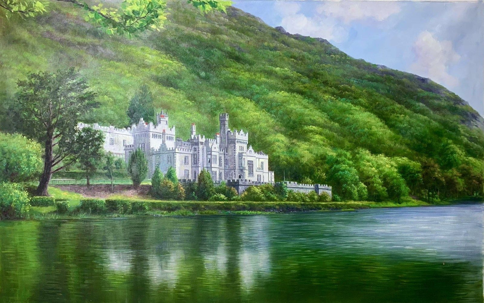 A pale abbey beside a still lake under a green hillside.